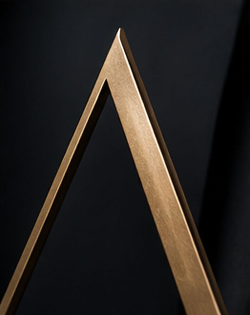 Brass peak sculpture echoing the Altus logo mark