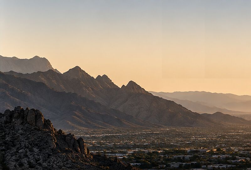 Black-and-white view of mountain ridgelines above a valley town at first light